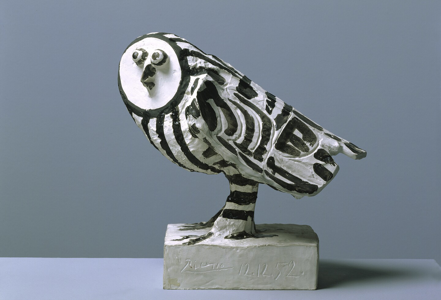Eulen-Skulptur in schwarz-weiß von Pablo Picasso auf weißem Sockel vor neutralem Hintergrund