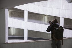Person fotografiert moderne Architektur mit geometrischen weißen Betonformen