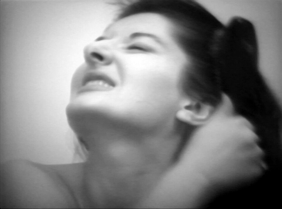 Schwarz-Weiß-Foto einer Frau, die nach oben blickt und sich bürstet