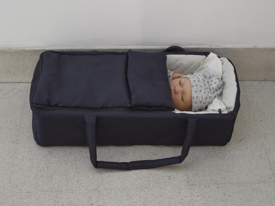 Dunkelblaue Babytragetasche mit Babypuppe