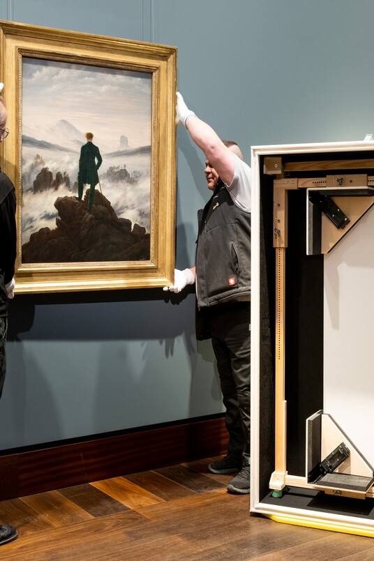 Ein Sammlungsverwalter der Hamburger Kunsthalle und ein Logistikexperte der Hasenkamp Group in der Hamburger Kunsthalle beim Abhängen/Verpacken des Werkes Wanderer über dem Nebelmeer (um 1817) von Caspar David Friedrich (1774–1840) in die nachhaltige arca-Transportkiste. Dauerleihgabe der Stiftung Hamburger Kunstsammlungen © SHK / Hamburger Kunsthalle / Hasenkamp Group Foto: Romanus Fuhrmann