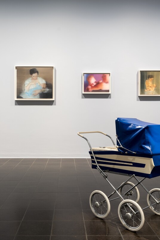 Ausstellungsansicht ISA MONA LISA: Gemälde der Serie S. mit Kind, 1995 von Gerhard Richter (*1932), © Gerhard Richter 2024 (28102024) und das Objekt Vogelfalle, 2001 von Andreas Slominski (*1959)