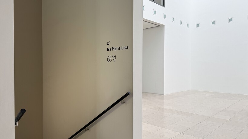 Galerieraum mit weißen Wänden und einer Treppe, die nach unten führt