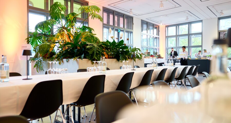 Das Foyer der Galerie der Gegenwart, langer Tafel, schwarzen Stühlen und Pflanzenarrangement