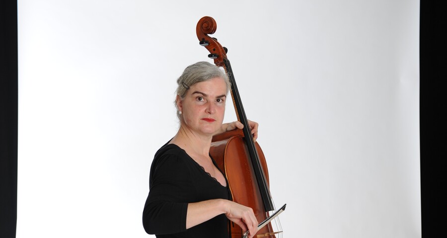 Frau spielt Kontrabass im Studio vor weißem Hintergrund