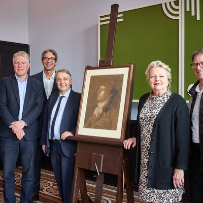Fünf Personen stehen neben einem gerahmten Philipp Otto Runge Zeichnung auf einer Staffelei bei einer formellen Veranstaltung.