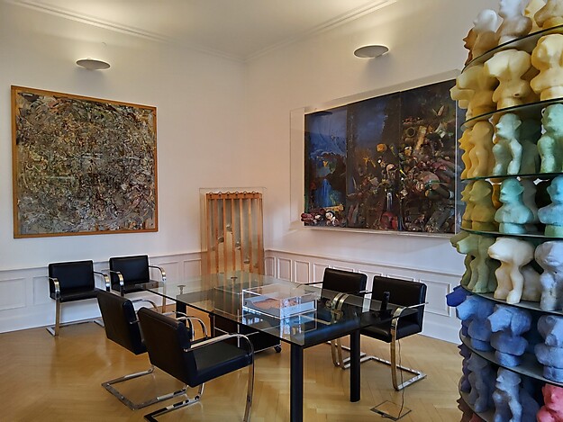 Innenraum des Dieter Roth Museums mit Lederstühlen und Glastisch, Kunstwerken an den Wänden